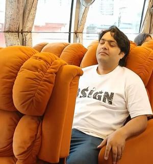 muž sedící na oranžovém sedadle v autobuse