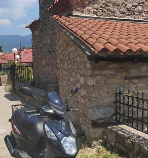 一辆摩托车停在一座石头建筑旁边
