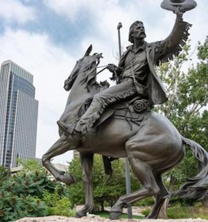 a statue of a man riding a horse with a flag