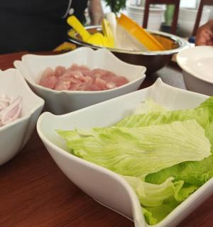 dřevěný stůl s miskami zeleniny a hlávkového salátu