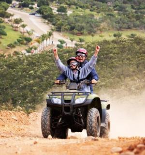 two people on a four wheeler on a dirt road