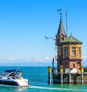 a boat in the water next to a lighthouse