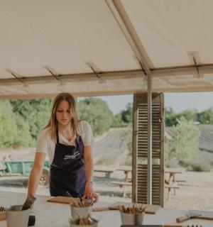 a woman standing under a tent preparing food
