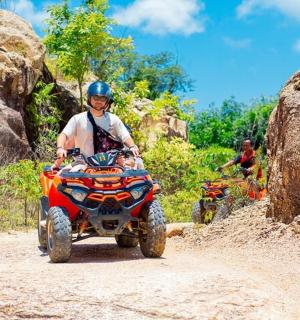 a man riding a four wheeler on a dirt road