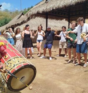 a man holding a drum in front of a group of people