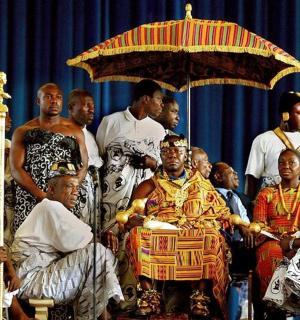 skupina lidí pózujících pro fotografii pod deštníkem