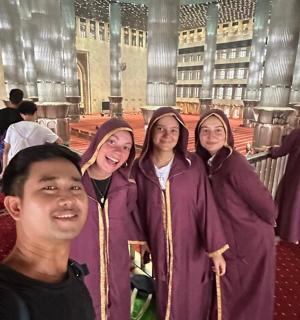 sekumpulan orang berdiri di atas tangga dalam sebuah bangunan