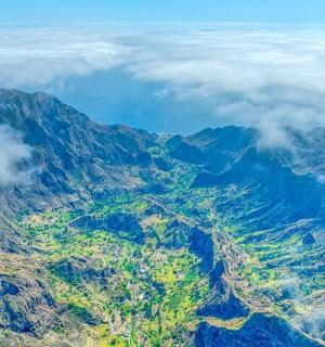an aerial view of a mountain with clouds
