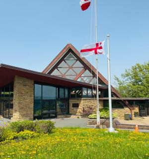 two canadian flags flying in front of a building