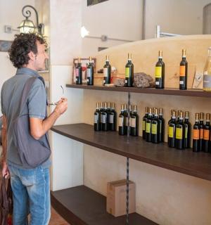 一名男子站在一排酒瓶前