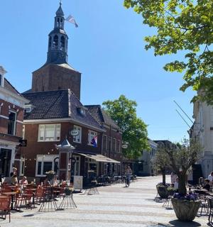 一条摆满桌椅的街道和一座带有钟楼的建筑