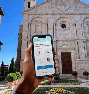 a person holding up a cell phone in front of a church