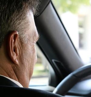 a man sitting behind the steering wheel of a car
