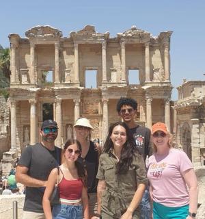 a group of people standing in front of the ruins