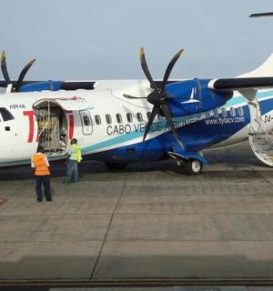 a blue and white airplane sitting on the runway