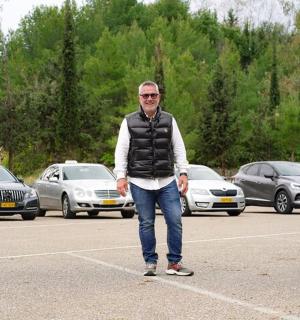 a man standing in a parking lot with cars