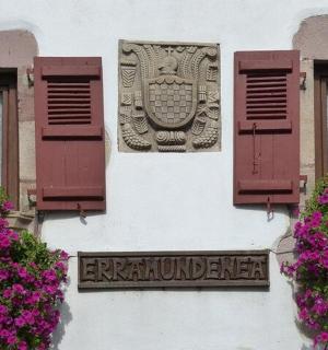 cedule na boku budovy s květinami