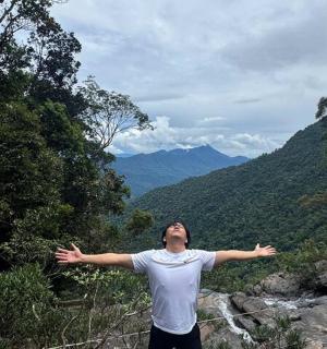 一名男子站在山上,张开双臂