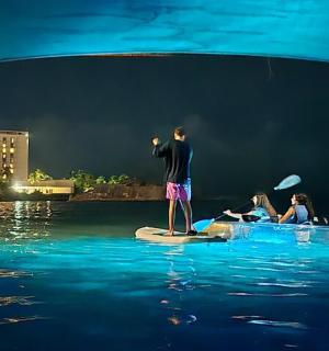 muž stojící na paddleboardu ve vodě