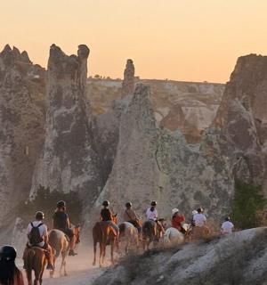 a group of people riding horses in a canyon