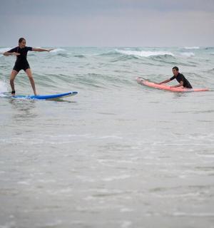 dues persones fent surf sobre taules de surf a l'oceà