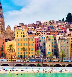a group of people on a beach in front of a city