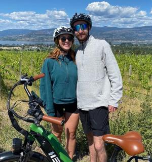a man and a woman standing next to a bike