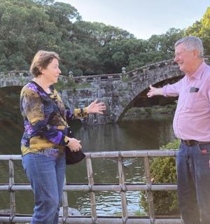 a man and a woman standing next to a bridge