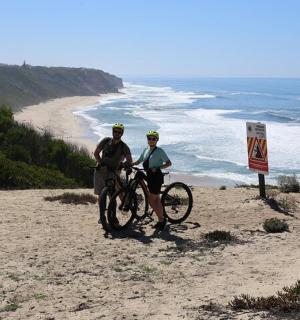 两个人在海边的山上骑自行车
