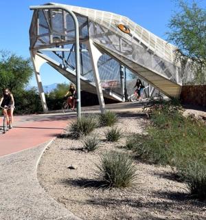 osoba jedoucí na kole pod mostem