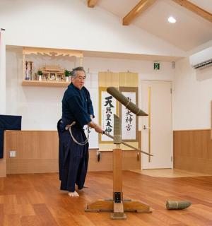 一名男子站在房间里，手里拿着棒球棒