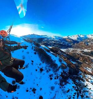 a man flying through the air while riding a parachute