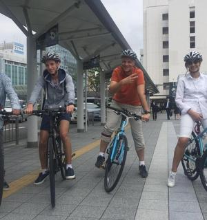 三个男人在人行道上骑自行车