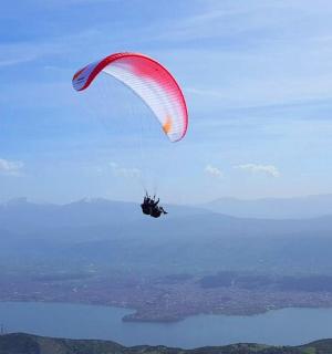 a person riding a parachute over a body of water