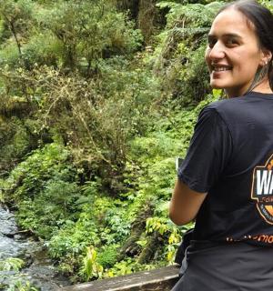 一位女士站在河边的桥上