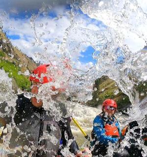 a group of people in a raft being sprayed with water