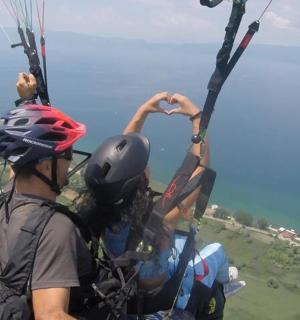 two people are making a heart shape on a parachute