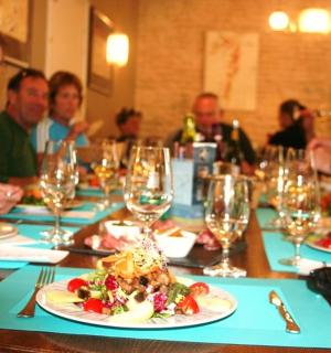 skupina lidí sedících u stolu s talíři jídla