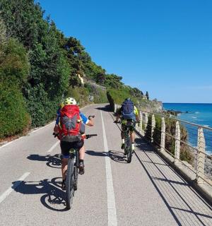 两个人在海边的路上骑自行车