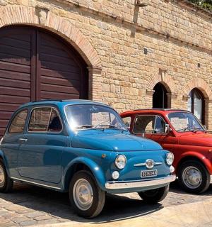 两辆旧车停在车库前