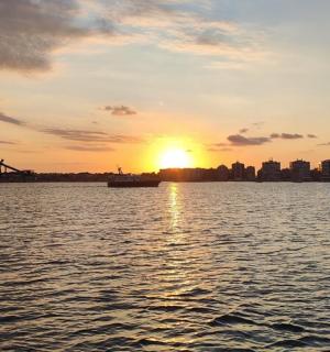 ein Sonnenuntergang über einem Gewässer mit einer Stadt