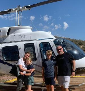 a group of people standing in front of a helicopter