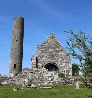 一座古老的石头建筑,有一座塔和一座雕像