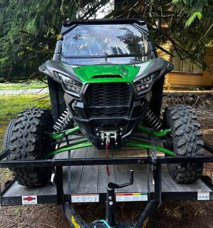 zelená čtyřkolka na přívěsu na dvoře