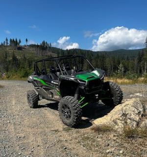 zelená čtyřkolka zaparkovaná na prašné cestě