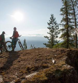 两个人骑着自行车站在山上