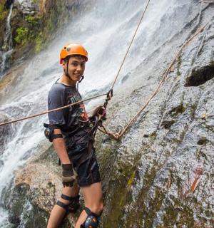 一名戴着头盔的男子站在瀑布前