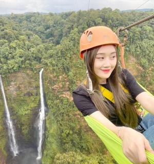 一名女子在瀑布前滑索