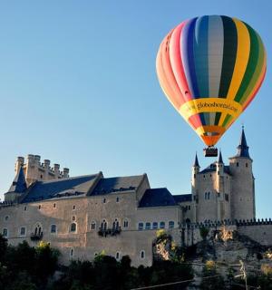 一只热气球在城堡前飞行