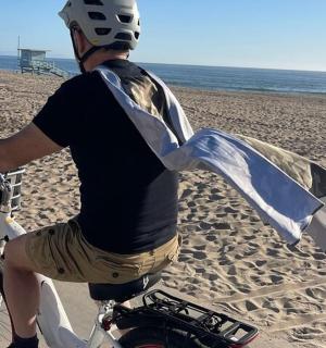 a man riding a bike on the beach